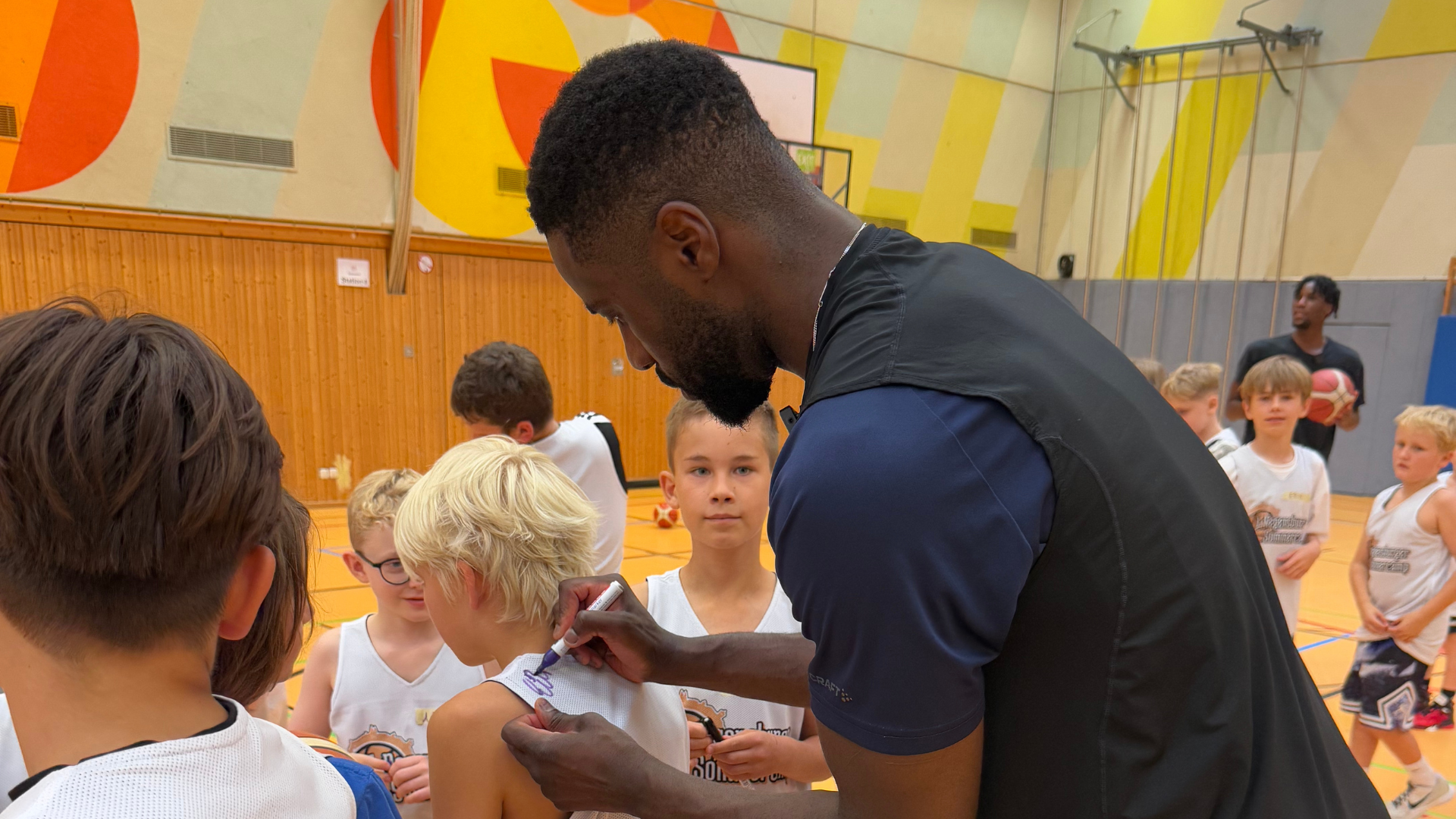 BBL Profi und Regensburger Eddy Edigin gibt Autogramme auf den Shirts