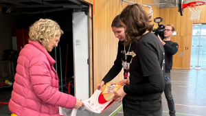 Übergabe eines Trikots und Fotos von einem Mädchenteam an die Sport Bürgermeisterin