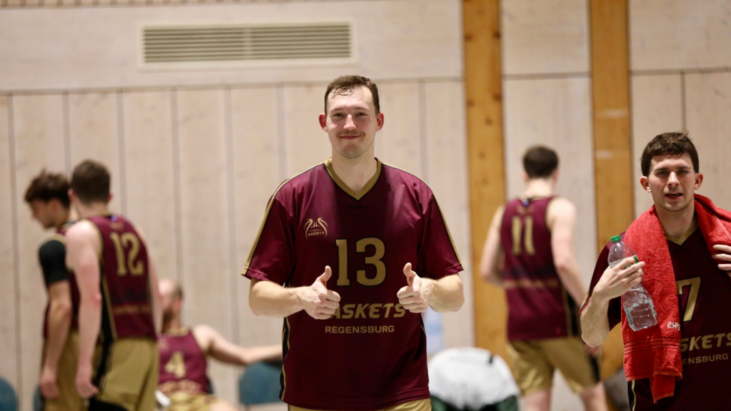 Basketballspieler mit Daumen nach oben in einer Basketballhalle